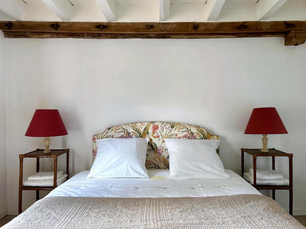 a bedroom with a bed with two lamps on both sides at La Grange à Grains - Château-Renard in Château-Renard