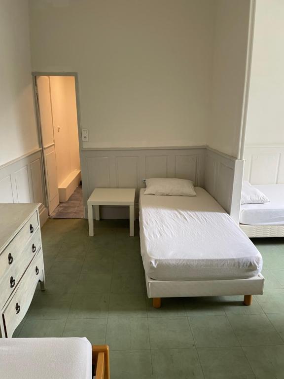 a bedroom with two beds and a table in it at Gîte de la cathédrale in Condom
