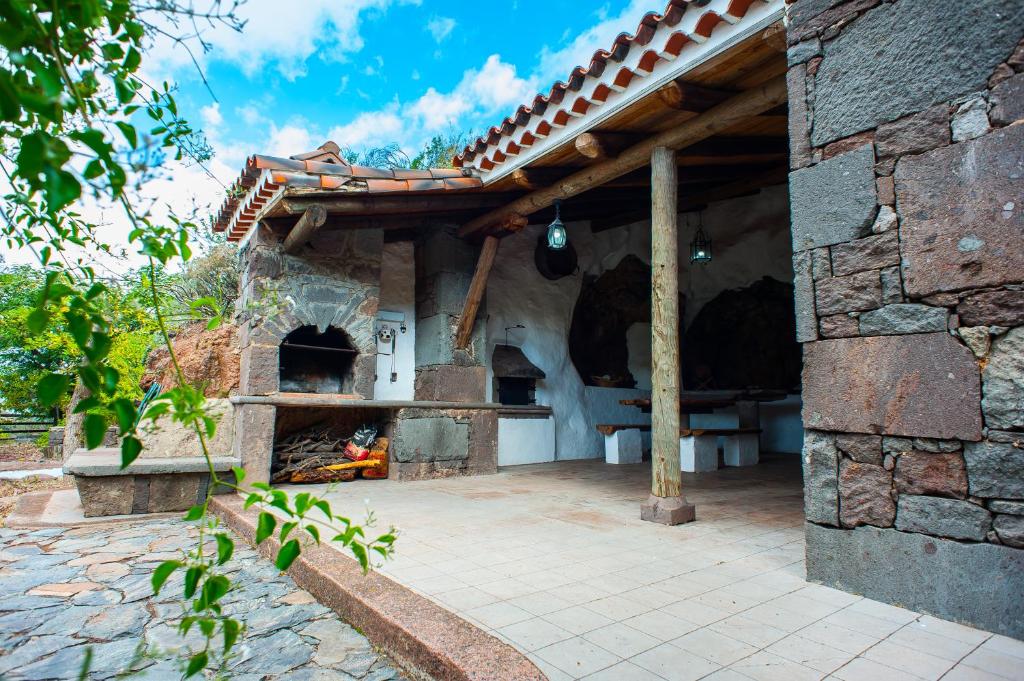 un horno de pizza al aire libre en un edificio de piedra en Casa-Cueva El Pastor, en Artenara