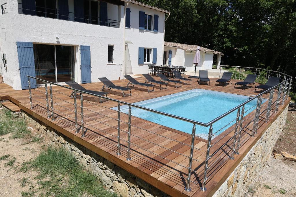 a deck with a pool with chairs and a table at Villa d'exception avec grande terrasse et piscine in Mons
