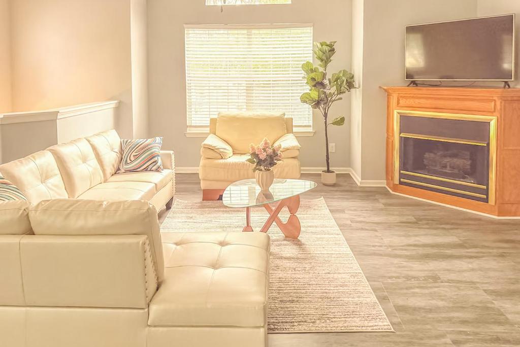 a living room with white furniture and a fireplace at Nyakio Suite in Chesapeake