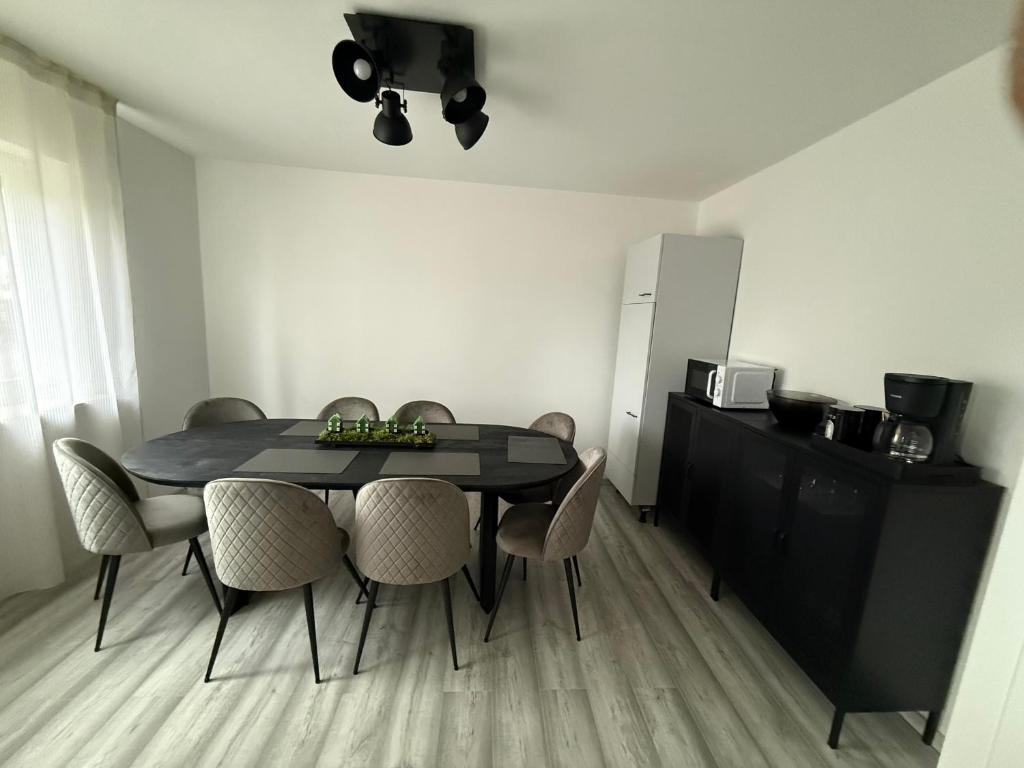 a dining room with a black table and chairs at Sofia2 in Urschmitt