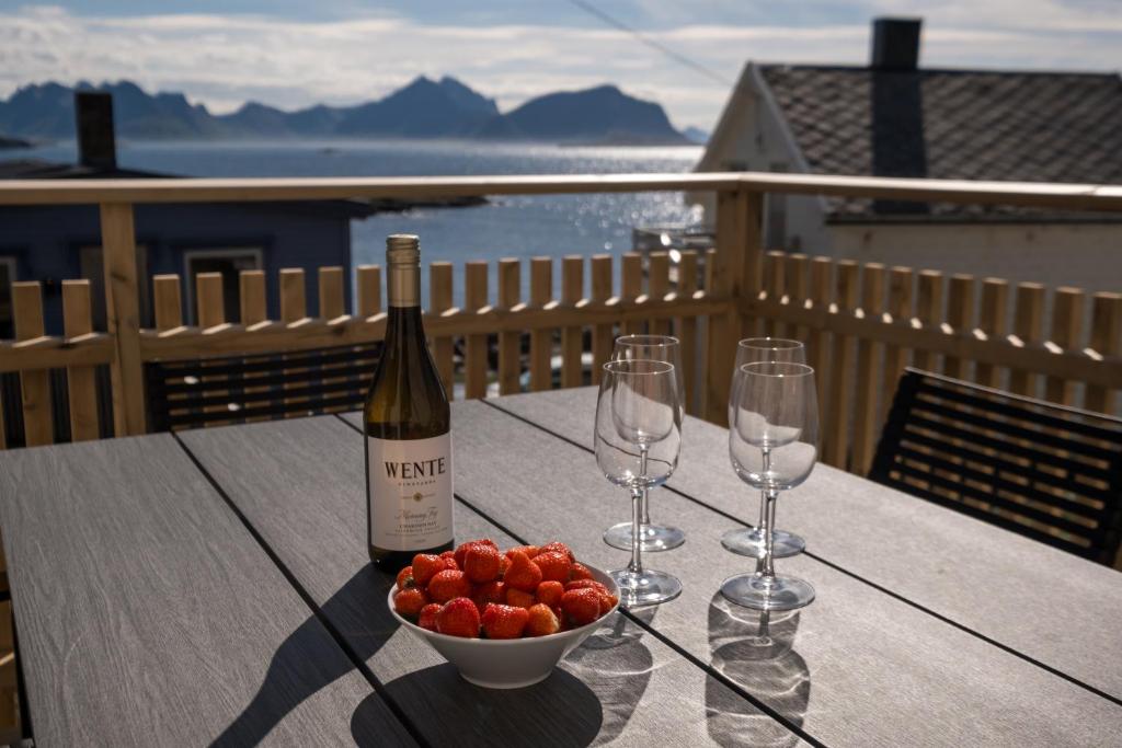 a table with two wine glasses and a bowl of fruit at Arctic Nest in Nyksund