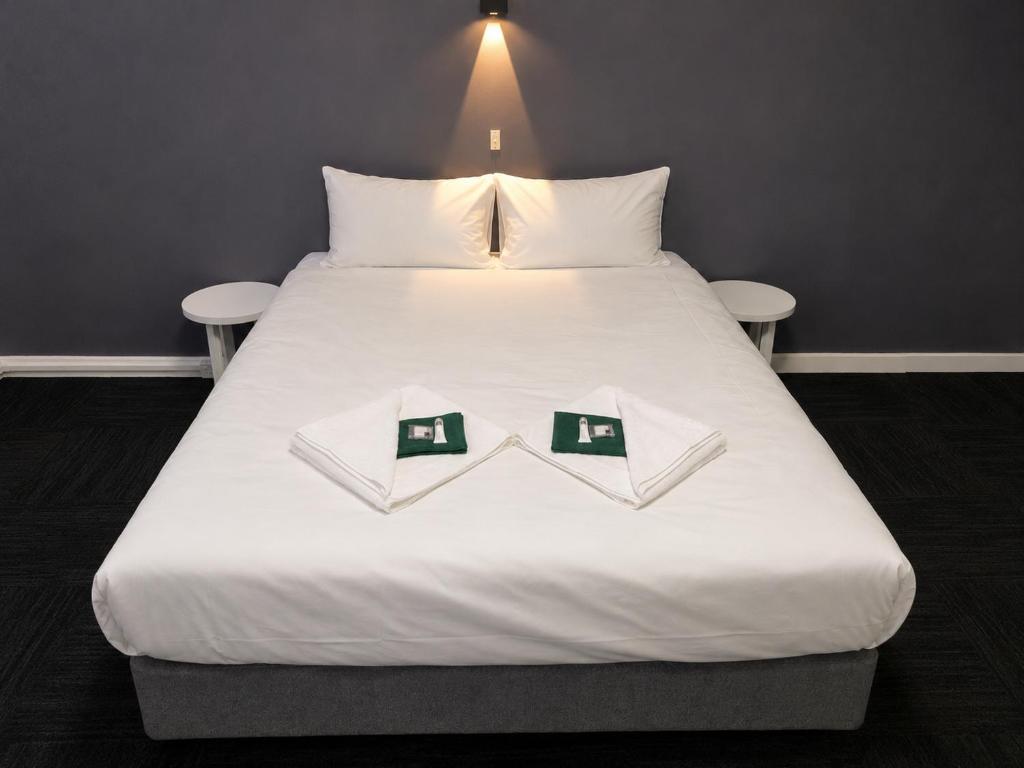 a large white bed with two books on it at Tintinara Hotel in Tintinara