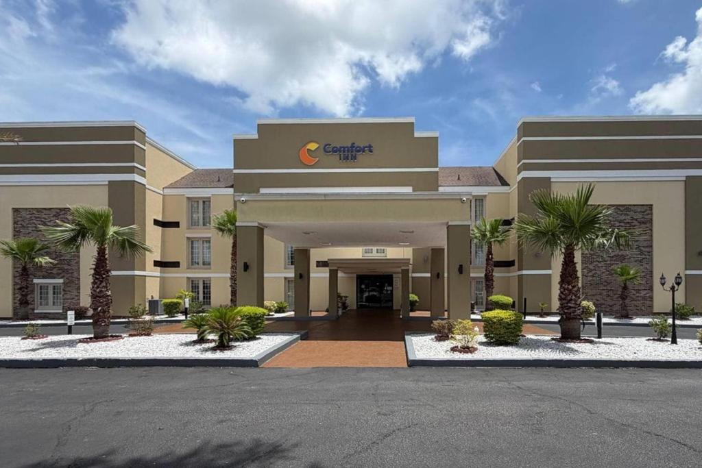 a hotel with palm trees in front of a building at Comfort Inn Savannah Midtown in Savannah
