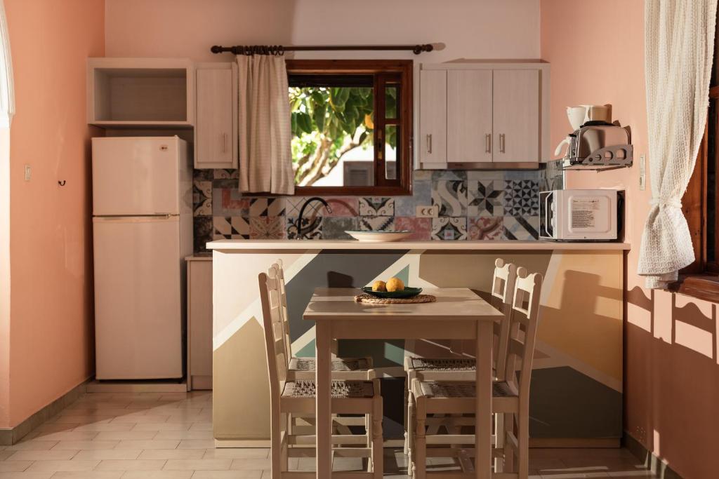 a kitchen with a table and chairs and a refrigerator at Alykes Park Bungalows in Alykes