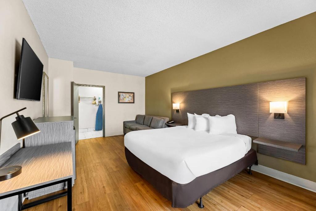 a hotel room with a large bed and a couch at Econo Lodge Greenville in Greenville