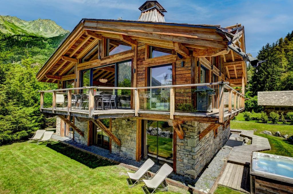 a log home with a wrap around deck and a large window at Chalet Black Stone in Chamonix