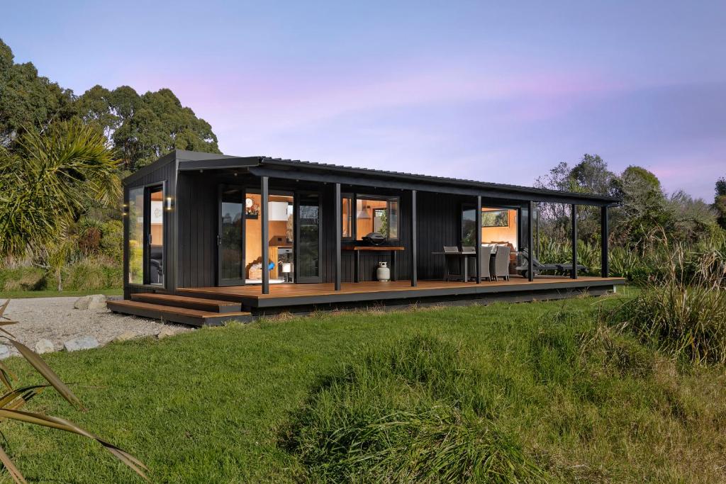 a black house in a field of grass at Relaxing Getaway in Pohara in Pohara