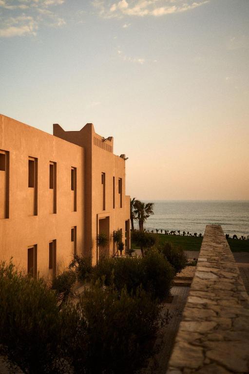 a building on the beach with the ocean in the background at The Riad by Blue Waves in Agadir