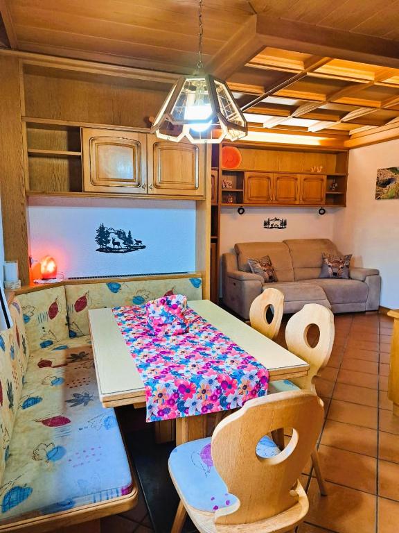 a kitchen and living room with a table and a couch at Il Nido casa vacanze in Varena