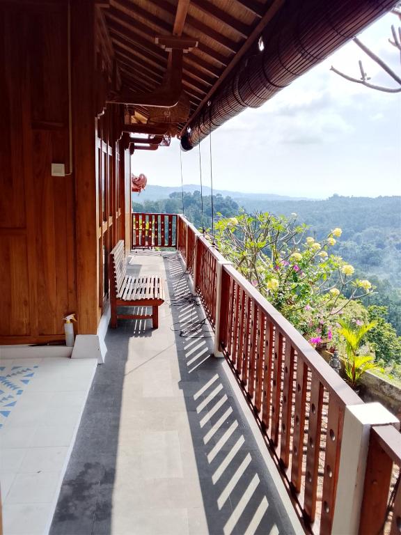 a balcony with benches and a view of the mountains at Mayong Awan Cita in Munduk