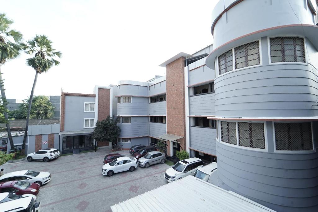 a parking lot with cars parked in front of a building at MAG Hotels in Patna