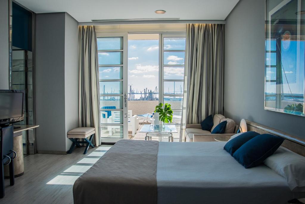 a bedroom with a bed and a view of the ocean at Hotel Puerto Sherry in El Puerto de Santa María