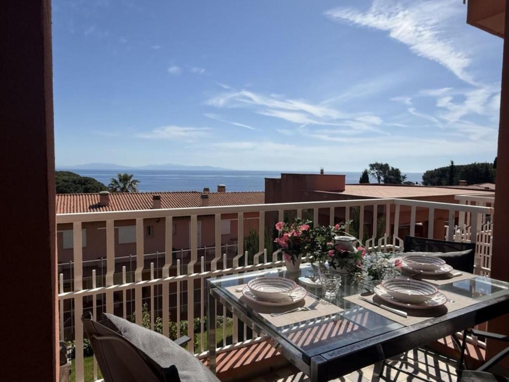 a table on a balcony with a view of a building at Capo d'Arco - Bougainvillea in Capo D'Arco