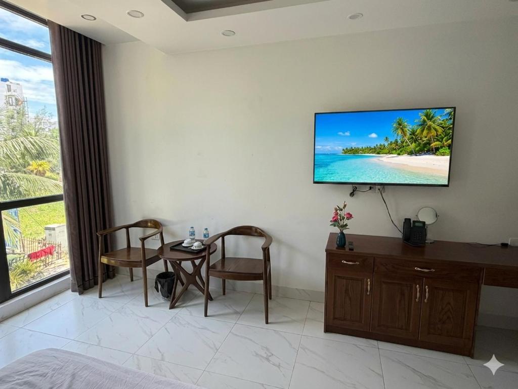 a room with a tv on a wall with a table at MoonKing FLC Sầm Sơn in Sầm Sơn