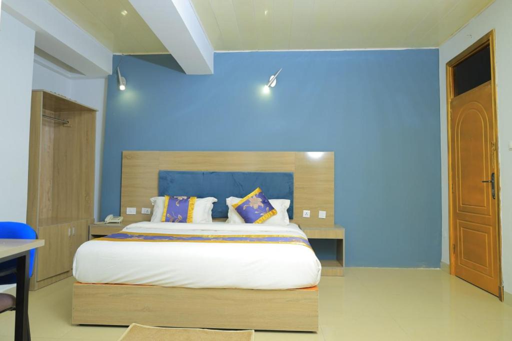 a bedroom with a large bed with a blue wall at Nile View Hotels in Shirih