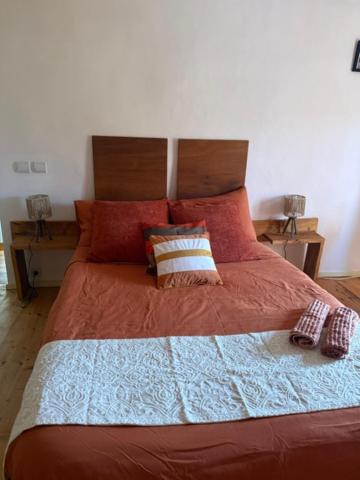 a bedroom with a large bed with red sheets and pillows at Petite champagne in Germignac