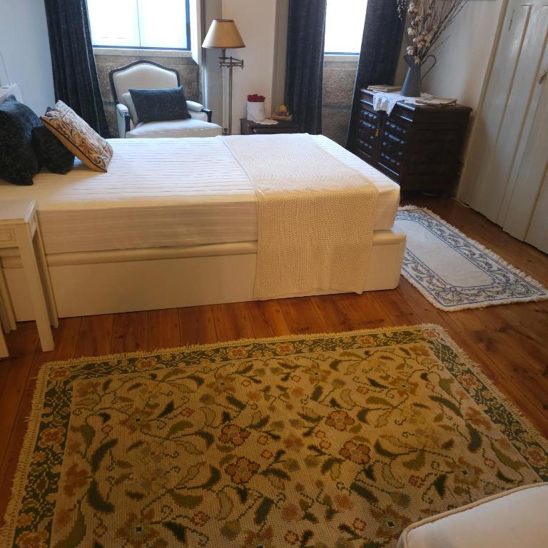 a bedroom with a bed and a chair and a rug at O Solarinho Azul in Oledo