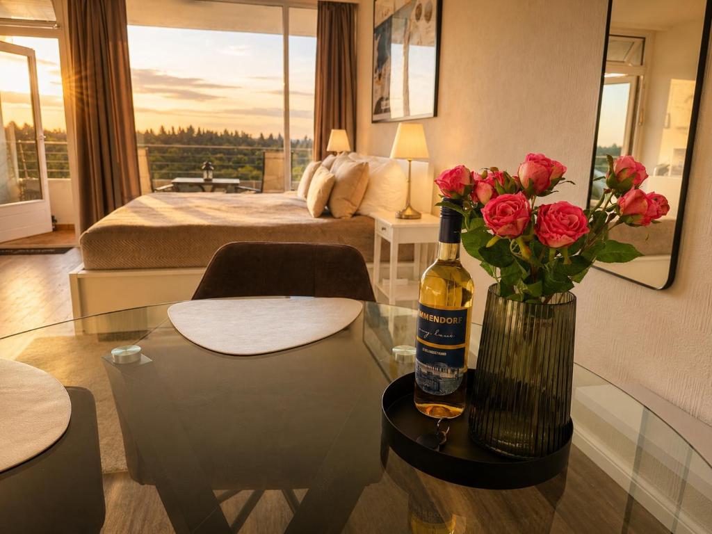 a room with a bottle of wine and flowers on a table at Timmendomizil - schöne Ferienwohnung in bester Lage - Sonnenseite in Timmendorfer Strand