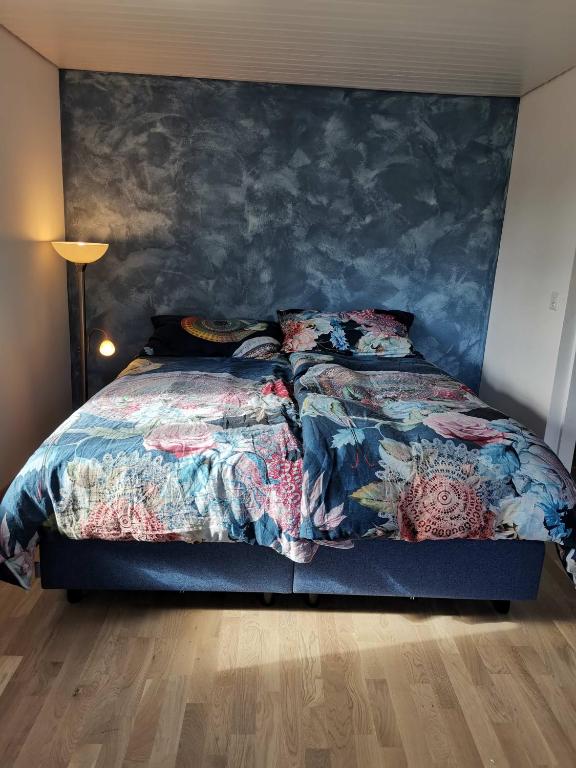 a bedroom with a bed with a blue wall at Maison mitoyenne avec terrasse in Asuel