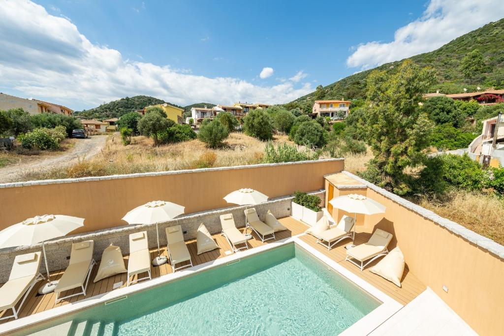 a swimming pool on the roof of a building with lounge chairs at Borgo Myricae - Giglio in Chia