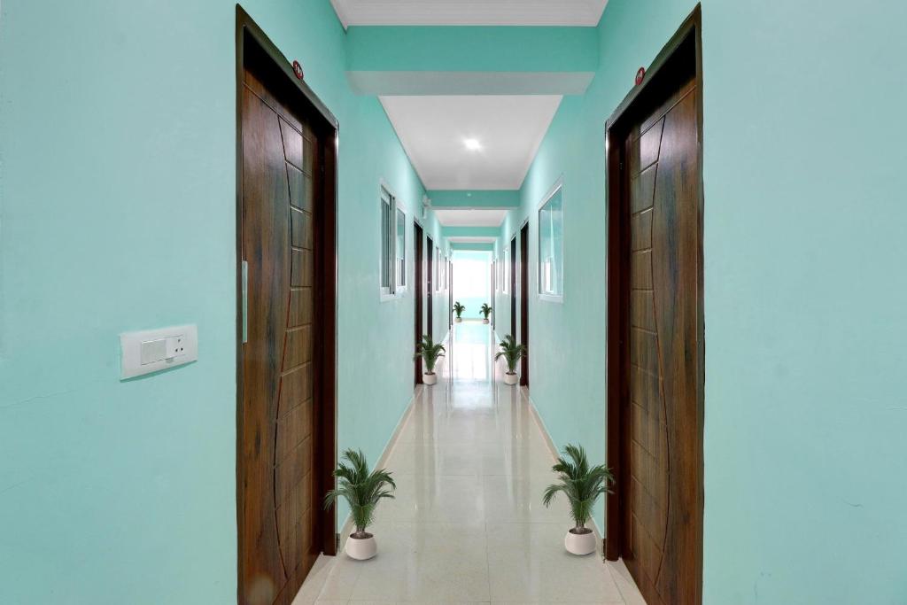 a hallway with blue walls and potted plants at Super Collection O The Kailash Hotel in Dehradun