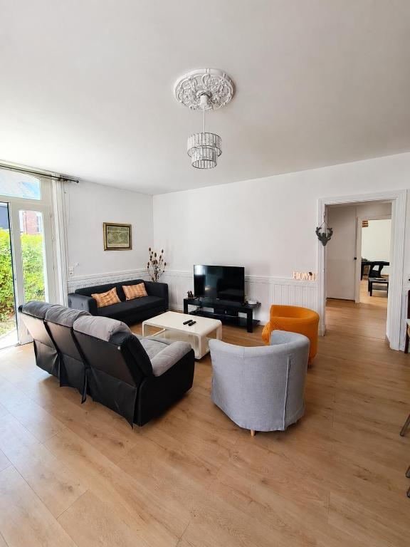 a living room with couches and a coffee table at Grand gîte 150 m2 - 4 chambres - Salle de jeux avec billard et fléchettes in Péronne