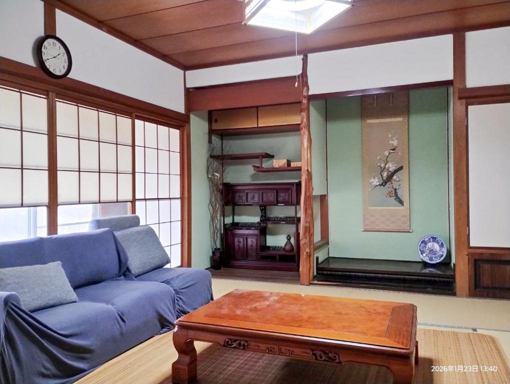 a living room with a blue couch and a coffee table at 和庵-Nagomian- in Kasaoka