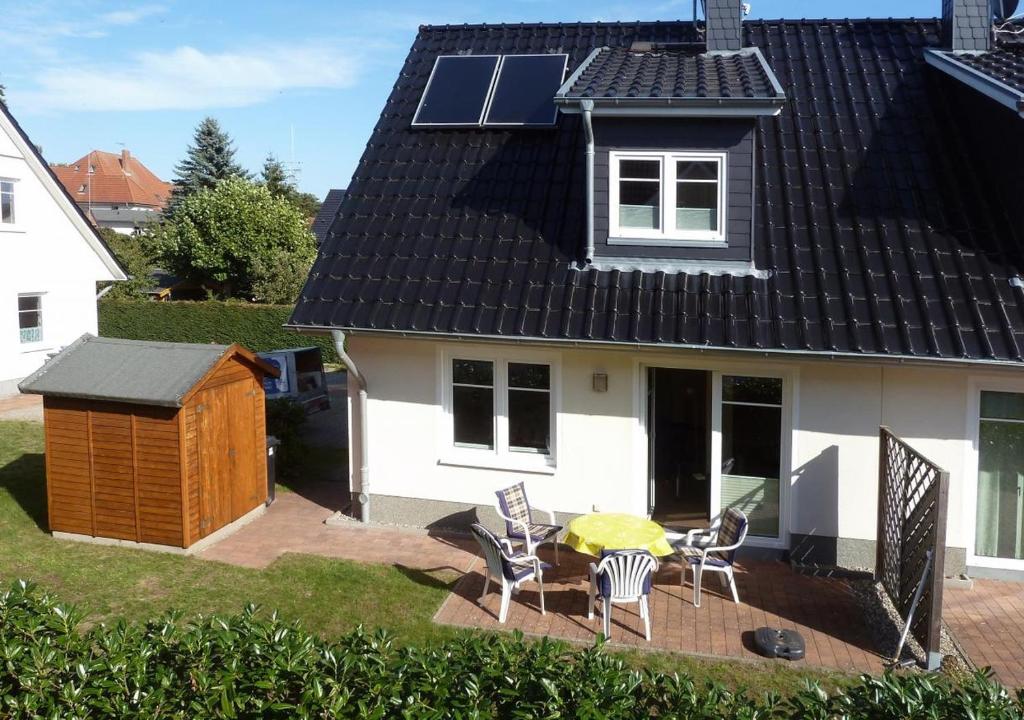 a house with a roof with a table and chairs at Hanne-Hus in Kühlungsborn