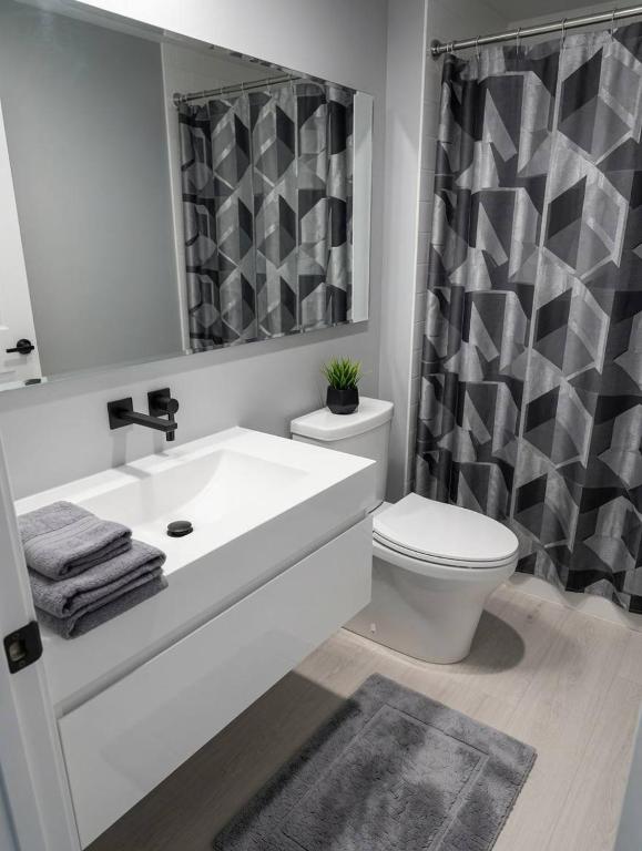 a bathroom with a white sink and a toilet at Sully House in Winnipeg