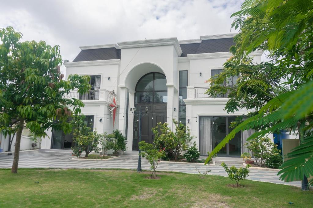 a white house with a black door at Luxury Mi-a Villa LaGi 4pn, huge salted pool, outdoor bbq and kara, up to 20 in Lagi