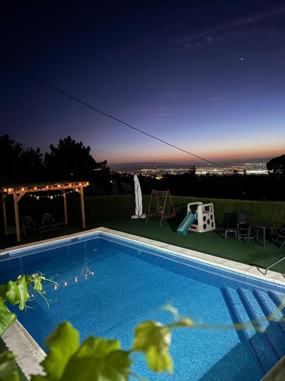 a swimming pool at night with a view of the city at Casa rural Balcón de Monachil in Monachil