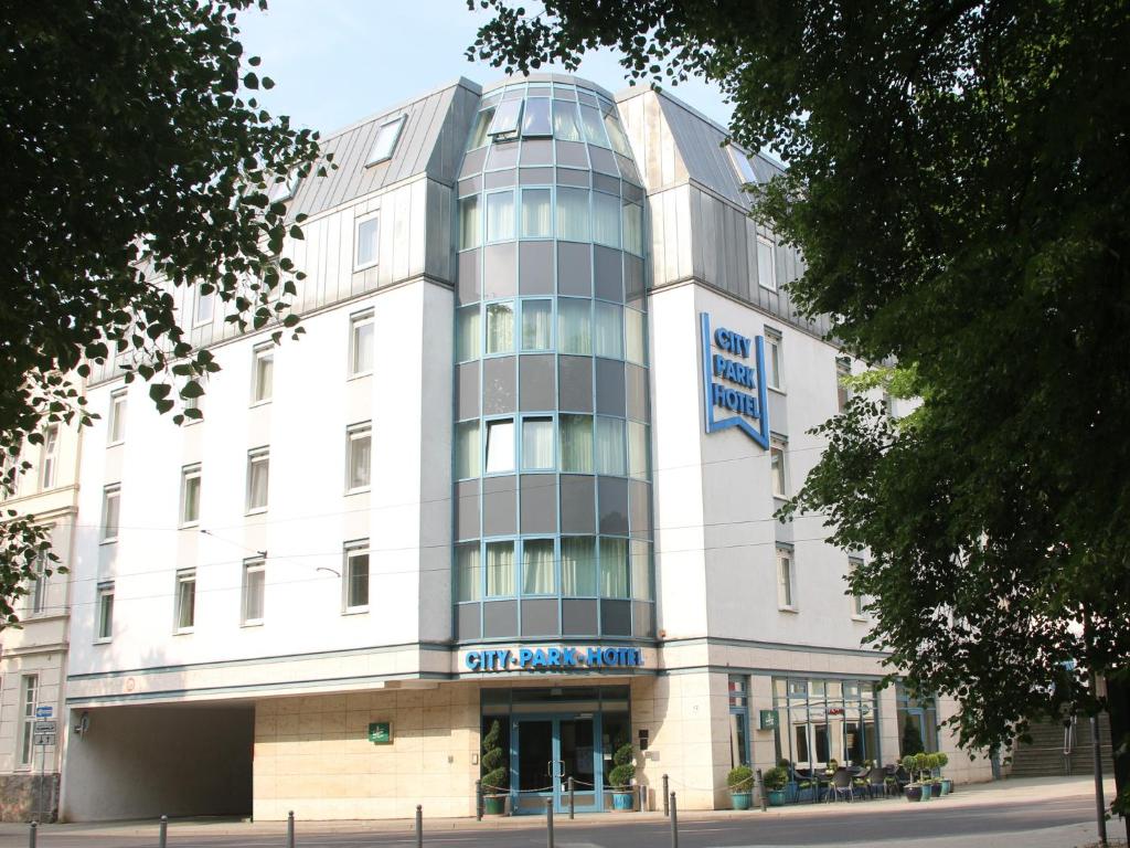 a large white building with a sign on it at City Park Hotel in Frankfurt Oder