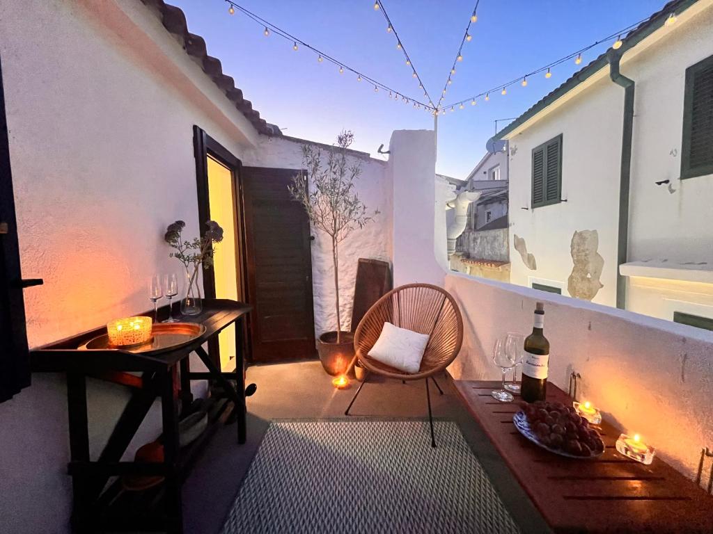 a patio with a table and a chair and wine glasses at Charming Casa Maria Pag in Pag