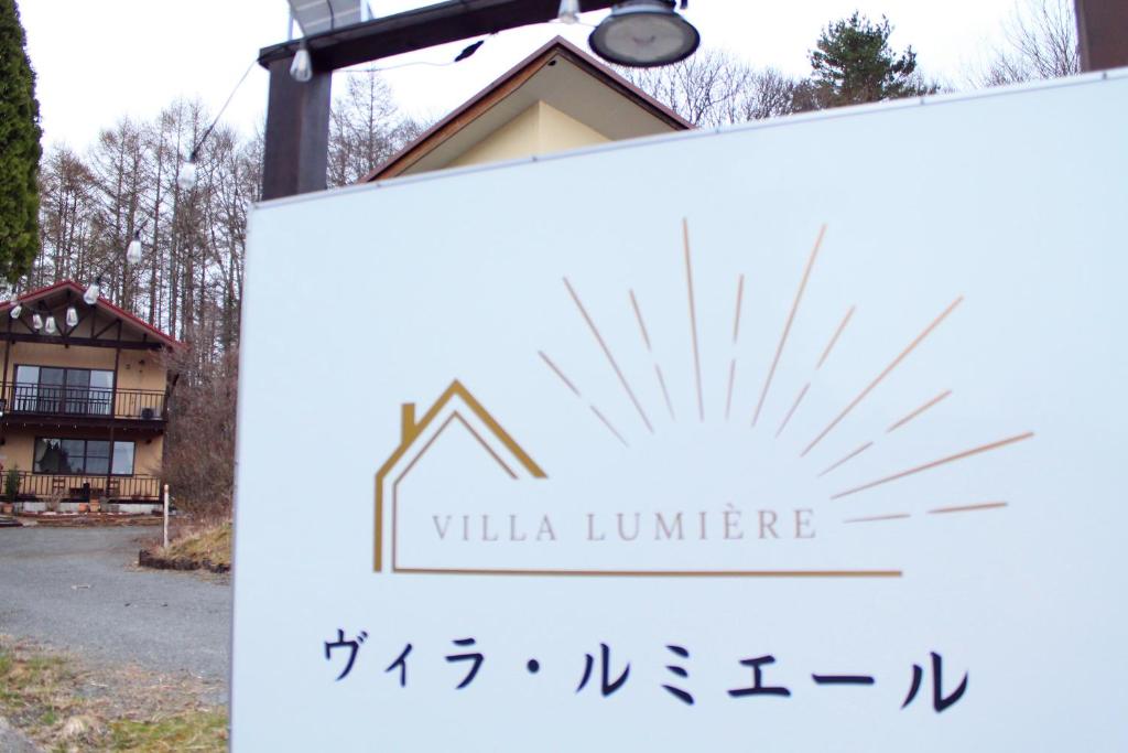 a sign for a villa lumiere in front of a house at ヴィラルミエール in Yamanakako