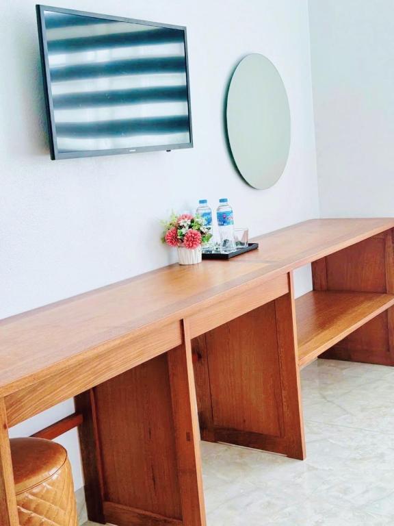 a wooden desk with a mirror on a wall at Nhà nghỉ Thảo Thảo Quan Lạn Minh Châu in Quang Ninh