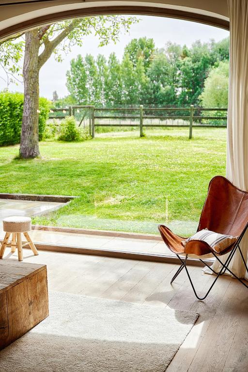 a chair in a room with a view of a field at Muntershof in Zottegem