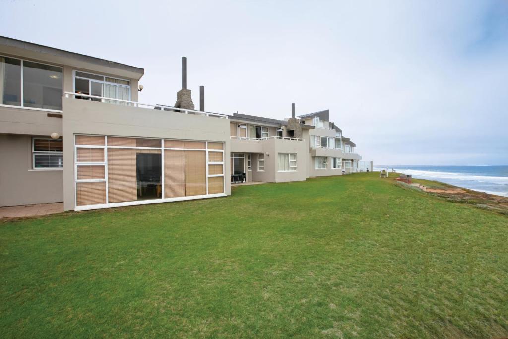 a house with a large yard next to the ocean at First Group Desert Rose in Hentiesbaai