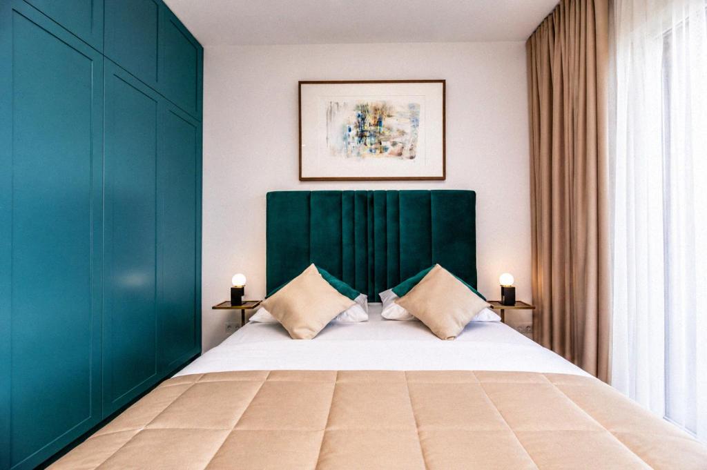a bedroom with a large bed with a green headboard at GreenRoom Kunigiškės in Palanga