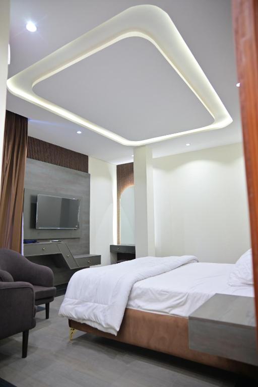 a bedroom with a large bed and a tv at Hotel Taj Palace in Sialkot