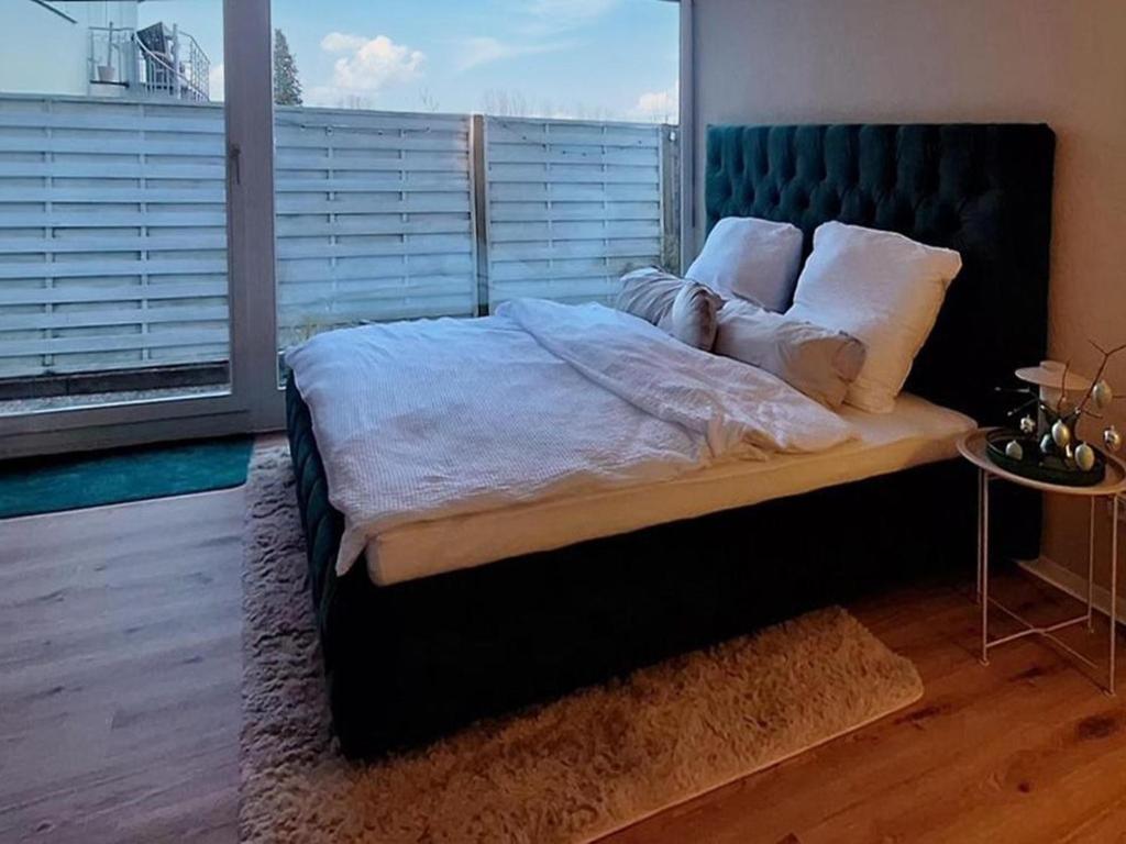 a bedroom with a large bed with a large window at Waldzauber Retreat in Nohfelden