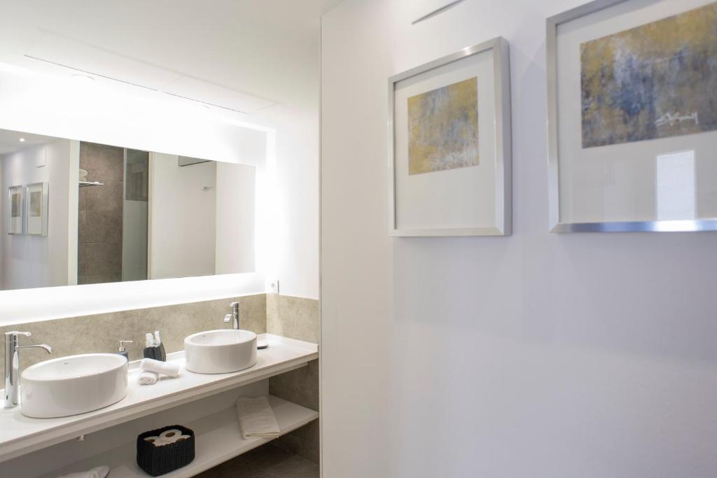 カルデス・デ・モンブイにあるCasa De Poble Termes Romanesのバスルーム(洗面台2台、鏡付)