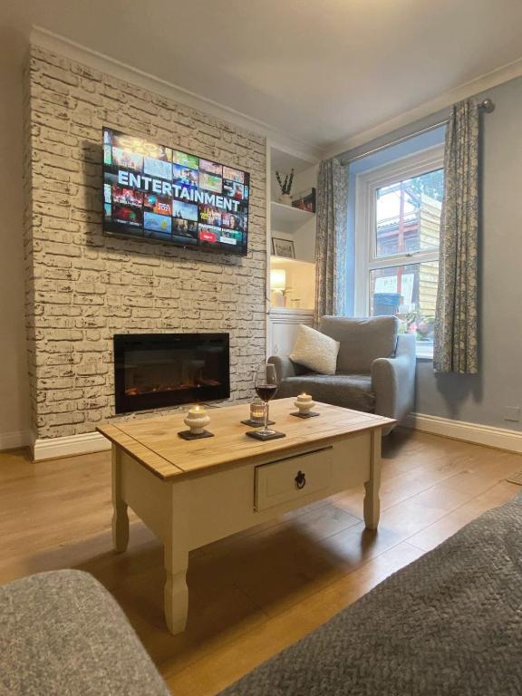 a living room with a coffee table and a fireplace at Welsh Yard Retreat in Penrith