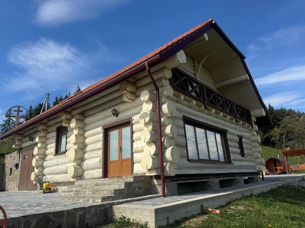 a small wooden house with a red roof at Садиба Сикитура in Verkhneye Vodyanoye