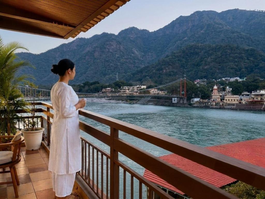 a woman standing on a balcony looking at the water at Sanskriti Vedic Retreat in Rishīkesh