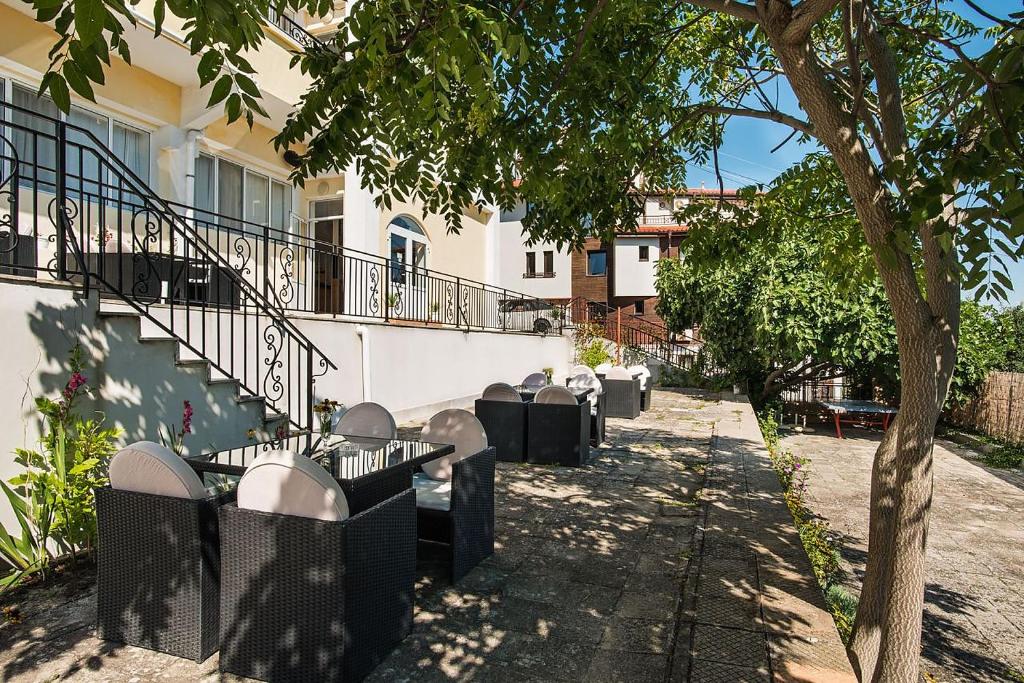 a row of tables and chairs next to a building at Effect Saint Mina - SELF CHECK-IN in Sozopol
