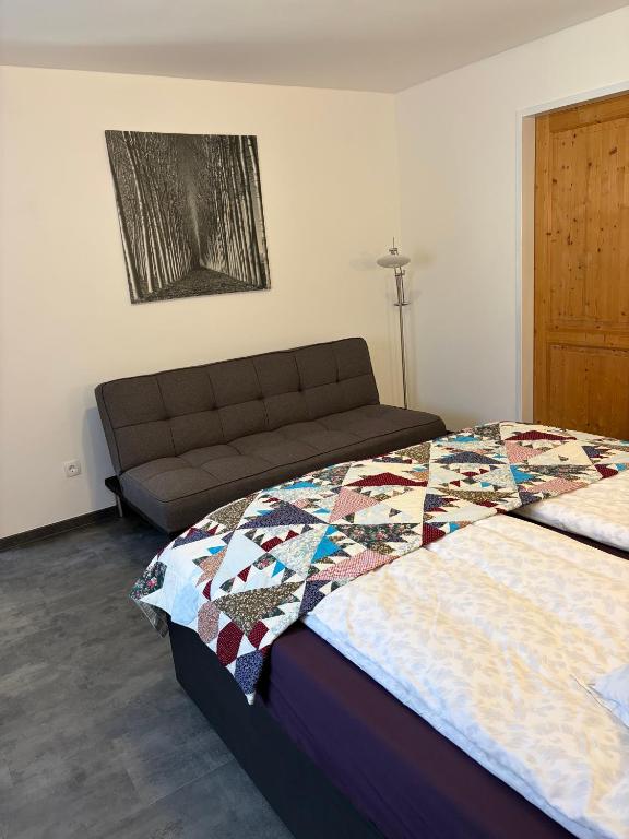 a bedroom with two beds and a couch at Langerhof in Hannersdorf
