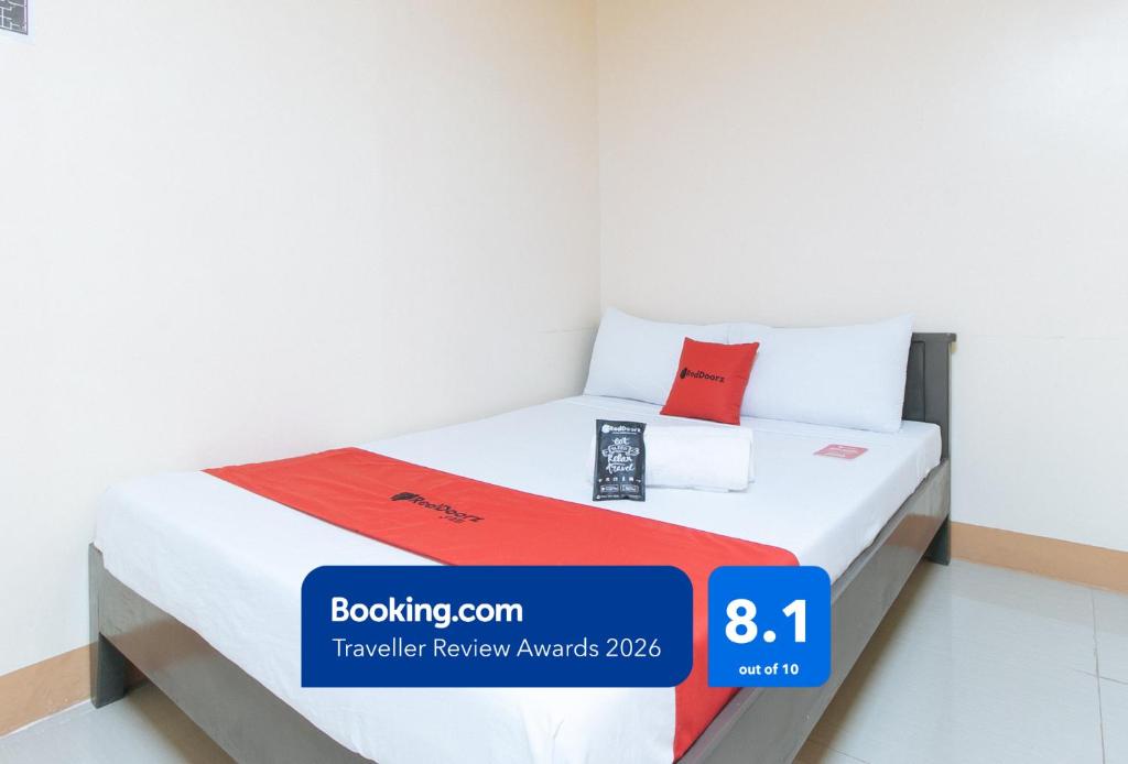 a bed in a room with a price sign on it at RedDoorz at Isabelita Hotel Tuguegarao City in Tuguegarao City