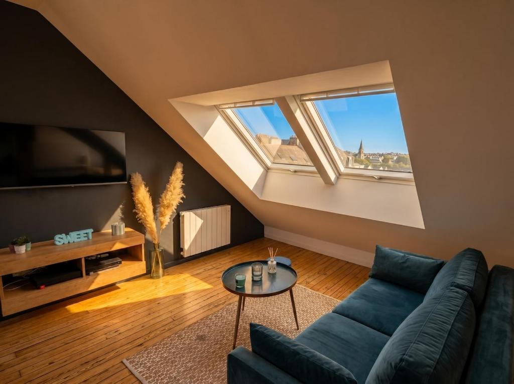 a living room with a blue couch and two windows at T2 lumineux, hypercentre Angers in Angers